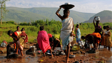 Women collect water outside of the village of Maliguda, (about 60km from Koraput) on Monday, September 21, 2009.  Many of these women are members of India's tribal community and are living in a forest village whose ancient lands were ceded by government to an aluminum mine. Development on nearby land threatens the villagers access to water.